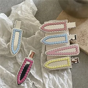 Pinces à cheveux argentées avec formes géométriques ondulées colorées aux tons pastel