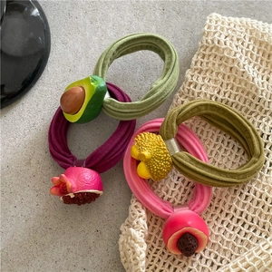Flat lay of colorful fruit hair ties with resin avocado, pineapple and peach charms