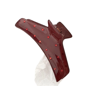 Elegante molletta per capelli rosso scuro lucido con strass su sfondo bianco