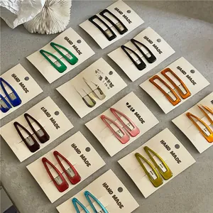 Flat lay of colorful drip oil BB hair clips in teardrop and rectangular shapes on cards