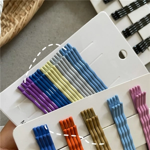 Close-up of matte rainbow wave hairpins set on a white display card in various pastel colors