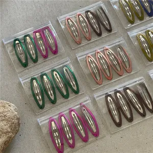 Colorful resin geometric drip oil oval BB hair clips set on textured stone surface