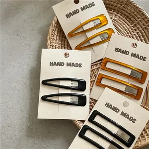 Detail of amber and black resin hair clips in teardrop and rectangular shapes