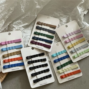 Colorful wavy bobby pins set in pastel tones displayed on cardboards for hair styling