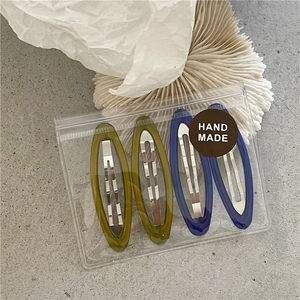 Set of 4 resin hair clips in blue and green colors shown in clear handmade packaging
