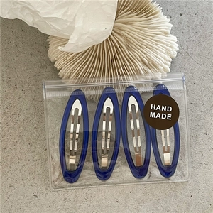 Set of four navy blue translucent oval BB hair clips in handmade brand packaging
