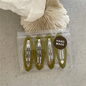 Set of four olive green translucent resin hair clips in a branded hand made package