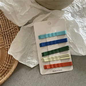 Set of 20 cream-colored rainbow wavy bobby pins organized on white display card