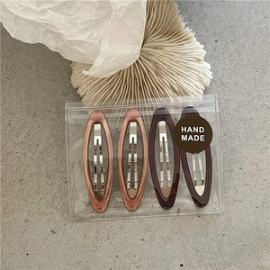 Detail of four-piece set oval marble resin BB hair clips in premium handmade packaging