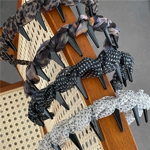 Detail of four leopard and polka dot hair hoops with non-slip teeth on wooden chair
