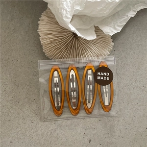 Set of four amber translucent resin oval hair clips with silver metal buckles