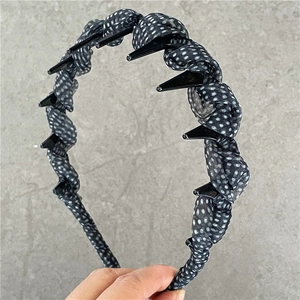 Detail showing the inner non-slip teeth of the black polka dot mesh headband