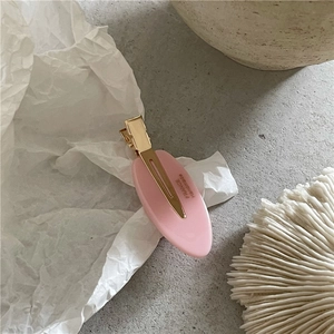 Détail de la pince à cheveux ovale rose avec attache dorée et mention France handmade