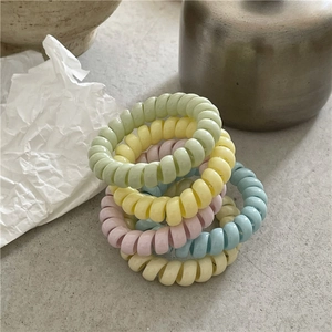 Détail macro d'élastiques à cheveux spirale pastel aux couleurs douces Morandi