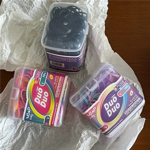 Macro view of colorful high-elastic TPU hair bands in transparent storage boxes