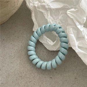 Gros plan sur l'élastique à cheveux spirale bleu clair avec une texture lisse