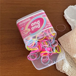 Close-up of colorful TPU elastic hair ties in a transparent jar with kids' branding