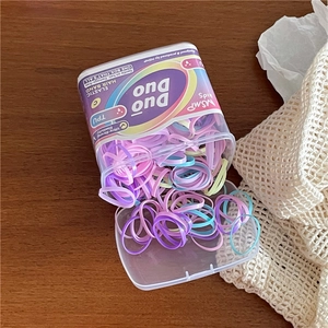 Close-up of high-elastic macaron-colored hair ties for kids in a clear storage box