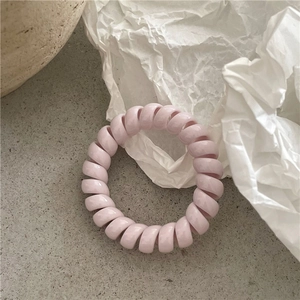 Détail de l'élastique spirale rose tendre avec texture en résine et haute élasticité