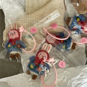 Handmade pink wool felt rabbit keychain with floral dress and red hooded cape in package