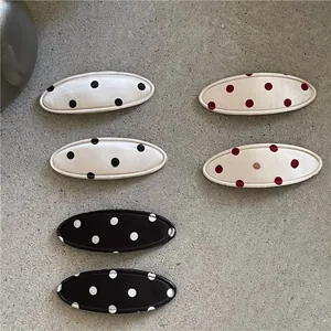 Détail de 6 barrettes ovales en tissu avec motifs à pois en trois couleurs pour les cheveux