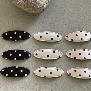 Lot de neuf barrettes ovales en tissu à pois en couleurs noir, beige et blanc
