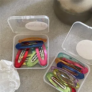 Fermagli per capelli ovali colorati in due scatole di plastica trasparente portatili