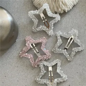 Dettaglio di fermagli per capelli a stella con cristalli e strass rosa e bianchi