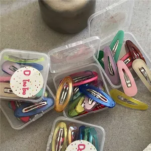 Dettaglio di fermagli per capelli BB colorati a goccia in scatole trasparenti