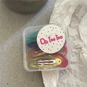 Fermagli ovali colorati per ragazze in una scatola di plastica trasparente portatile