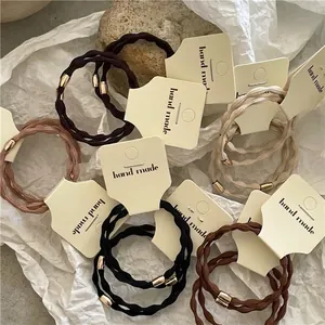 Elastic hair ties set in earth tones with gold metal beads on minimalist display cards