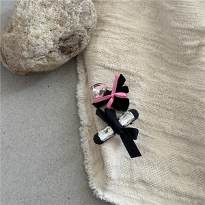 Close-up of vintage black velvet and satin hair clips with pink heart and clear gems