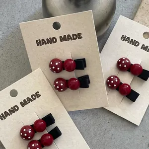 Cute red mushroom hair clips with white polka dots on wooden card, set of three