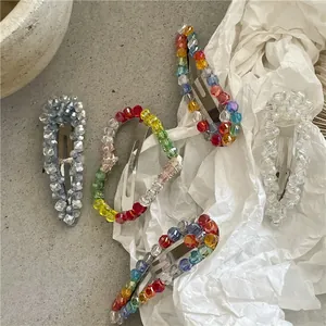 Detail of beaded water drop and heart snap hair clips with colorful crystals