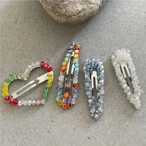 Detail of four handmade beaded BB hair clips with crystal hearts and water drop shapes