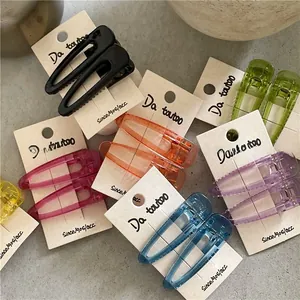 Macro detail of colorful translucent drop hair clips set with minimalist hollow U-shape design