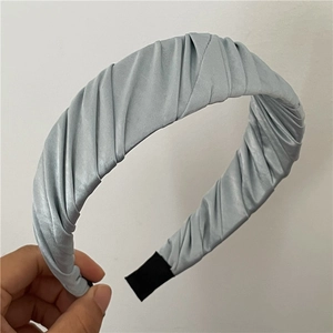 Détail du serre-tête en satin plissé bleu clair avec texture de tissu froncé élégant
