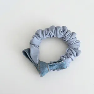 Blue denim bow hair tie scrunchie with yellow stitching and faux pearl beads accent