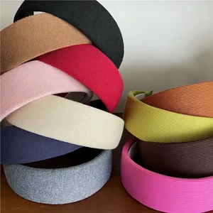 Detail showing various colors of wide knitted headbands with ribbed fabric textures