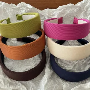 Close-up of six colorful ribbed knit wide headbands in vibrant shades on white background