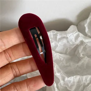 Close-up of burgundy velvet water-drop BB hair clip with soft flocking texture and black metal base