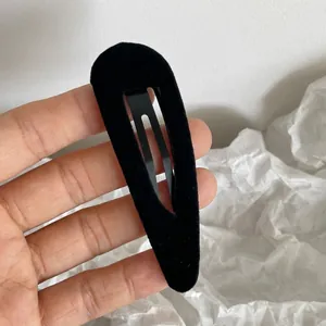 Detailed close-up of a teardrop-shaped black velvet hair clip with premium soft texture