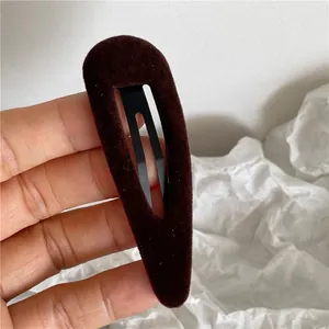 Detailed view of dark brown velvet flocked teardrop snap clip with metal inner grip
