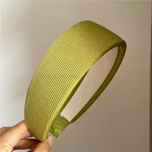 Detail of avocado green ribbed fabric headband with inner anti-slip lining and wide design