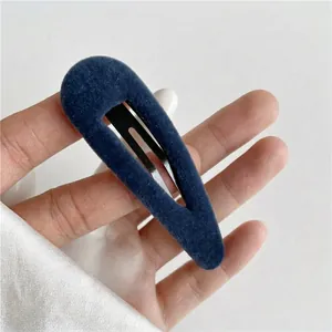 Minimalist navy blue velvet fabric snap hair clip with a sleek black metal base for women