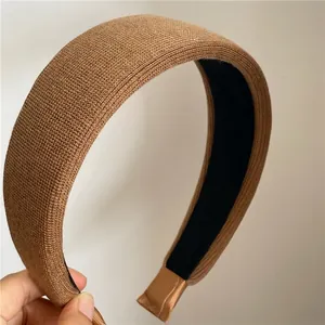 Close-up of brown knitted wide headband showing vertical textured fabric and soft lining