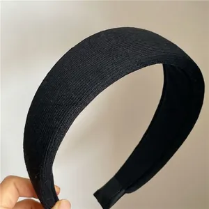 Detailed close-up of thick black ribbed fabric headband with vertical knitted texture