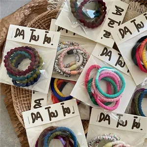 Creamy color elastic hair tie set with ruffled wave patterns and colorful beads in a basket