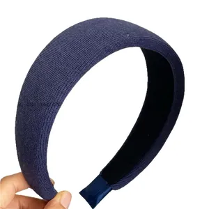 Thick navy blue knitted headband with wide padded design and soft ribbed fabric texture