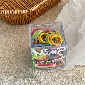 Close-up of colorful seamless elastic hair ties in a cute cartoon branded acrylic box